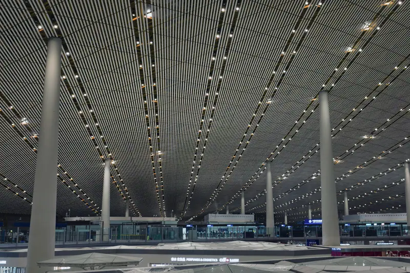 Airport terminal interior under an illuminated ceiling