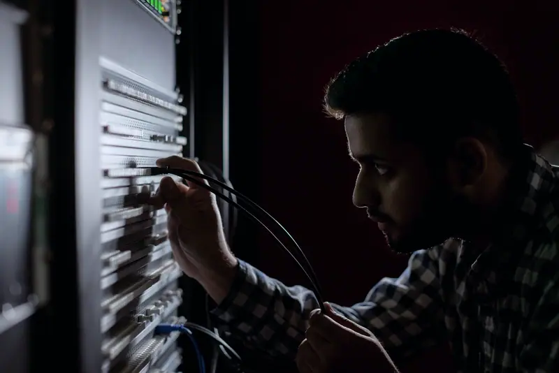 Engineer checking cabling in an equipment rack