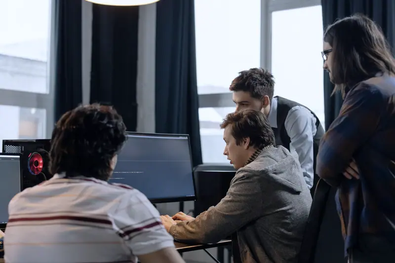 Engineers gathered around a workstation reviewing work together