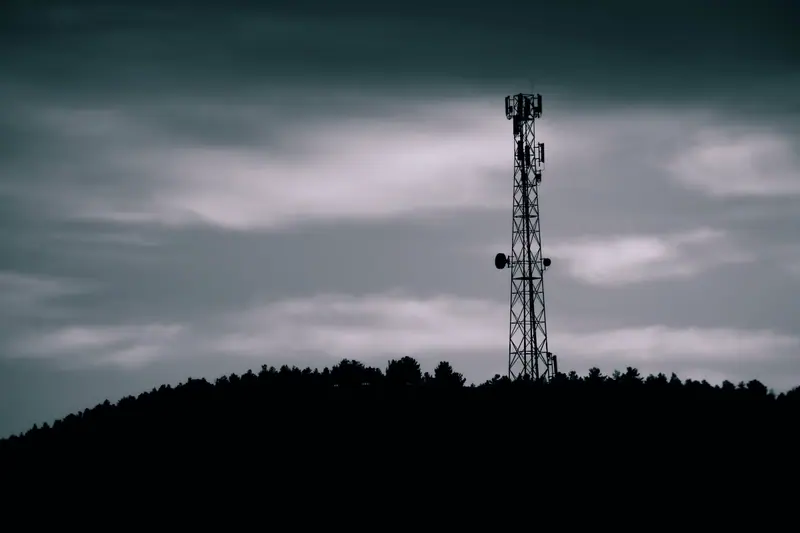 Telecom tower silhouetted against the evening sky